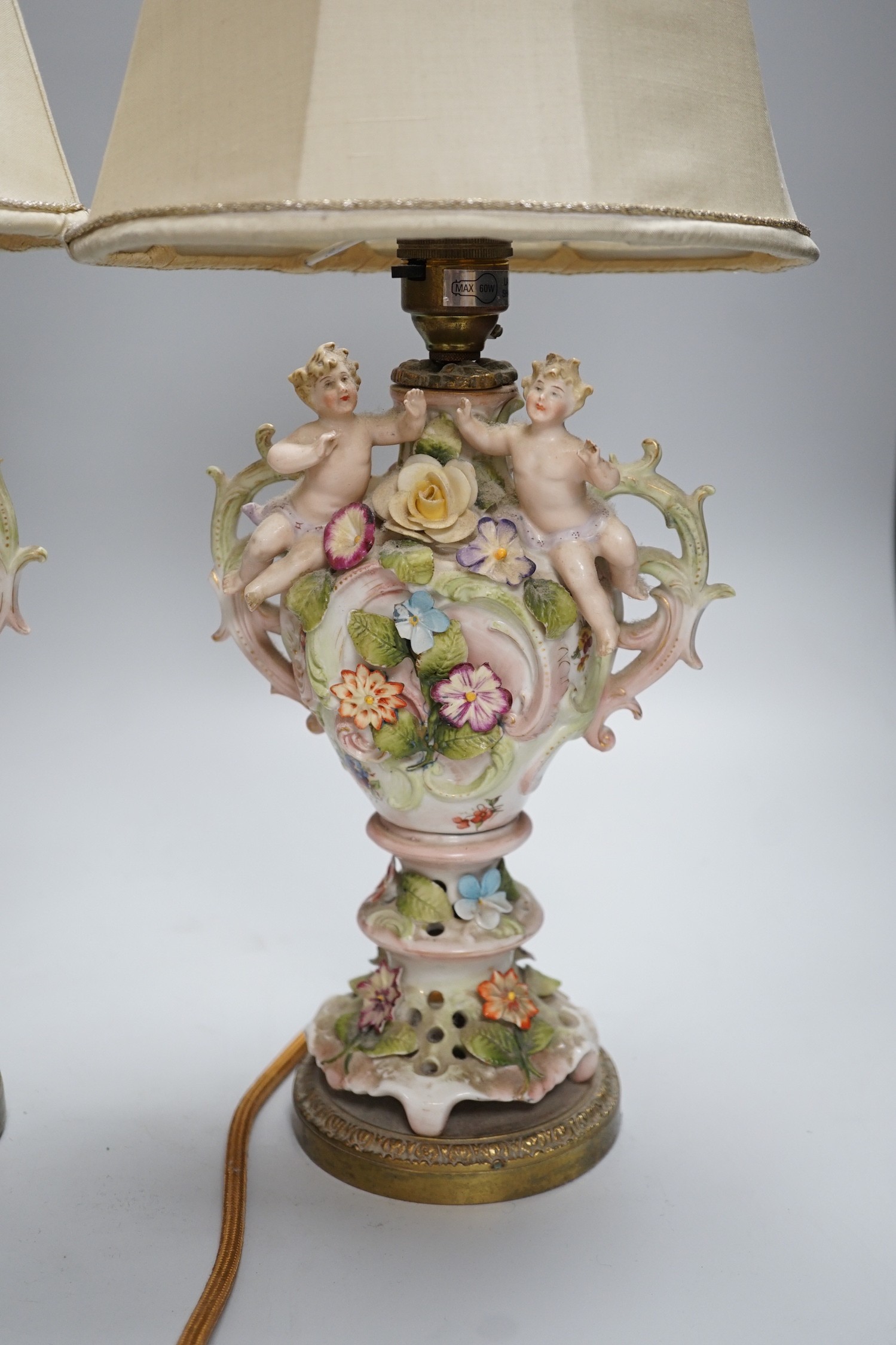 A pair of German porcelain flower encrusted lamps, height 24cm